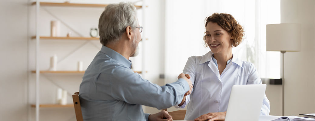 Image of senior male shaking hands with a hearing care professional